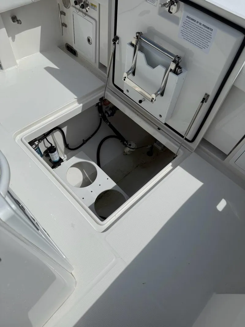 Slide: The Image of 2021 Regulator 31 boat storage compartment with open hatch, showcasing interior wiring and components. - 14