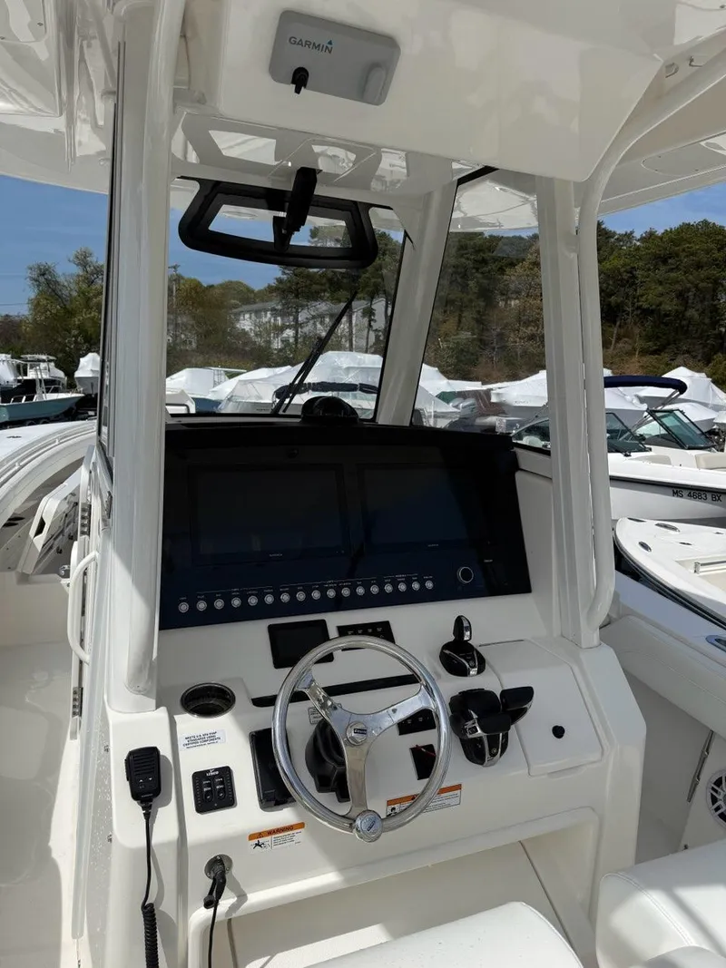 Slide: The Image of 2021 Regulator 31 boat cockpit with advanced navigation system and steering wheel. - 2