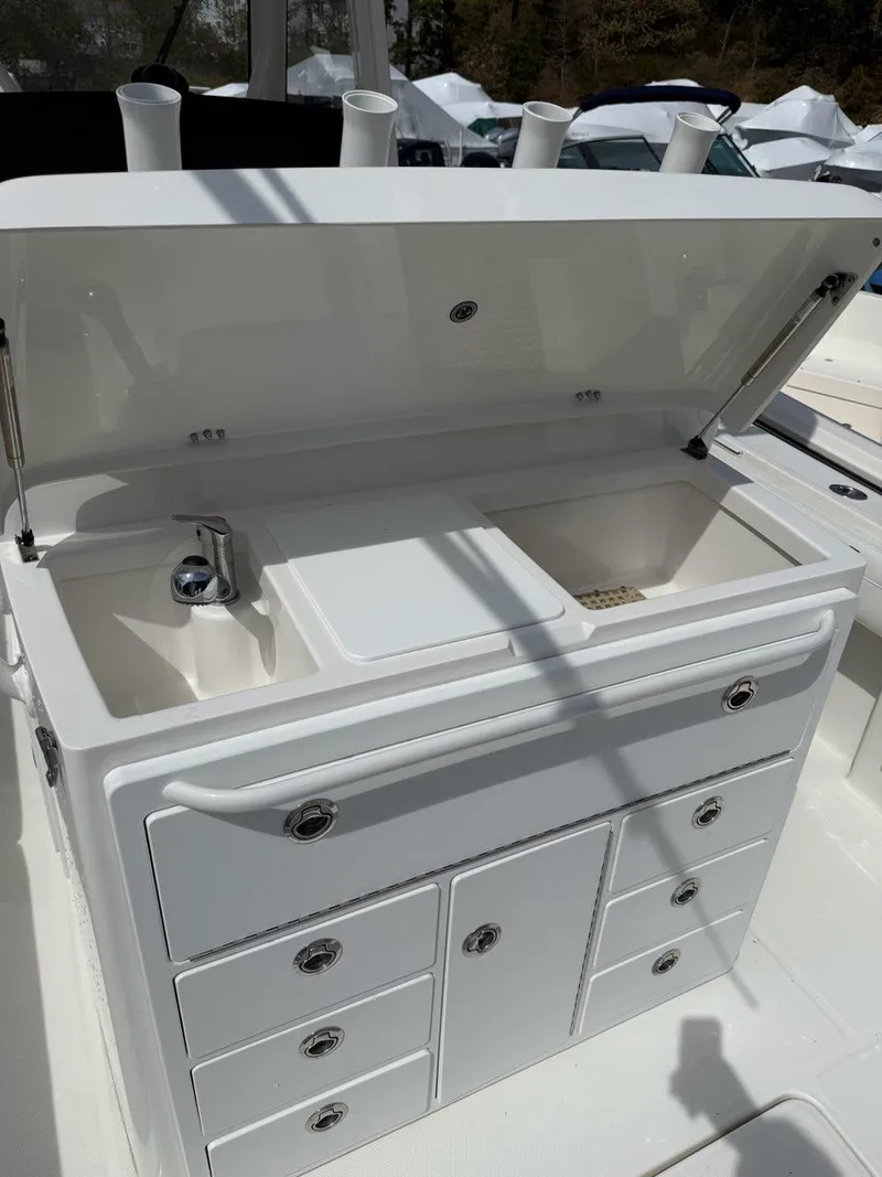 Slide: The Image of 2021 Regulator 31 boat with open storage compartments and sink. - 7