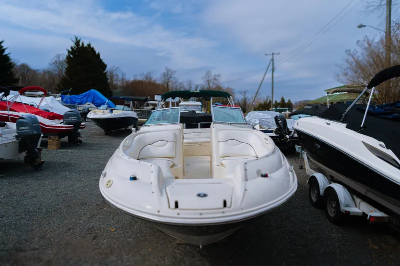 Slide: The Image of 2003 Sea Ray 240 Sundeck boat parked in a marina with other boats. - 1