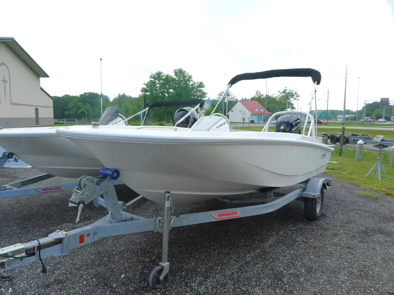 Slide: The Image of 2025 Boston Whaler 160 Super Sport boat on trailer, parked outdoors. - 2