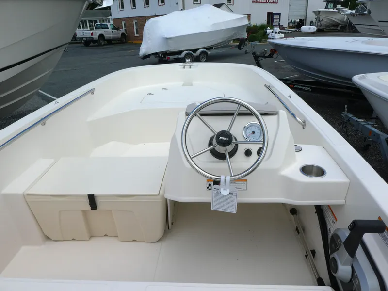Slide: The Image of 2025 Boston Whaler 160 Super Sport boat interior with steering wheel and seating. - 3