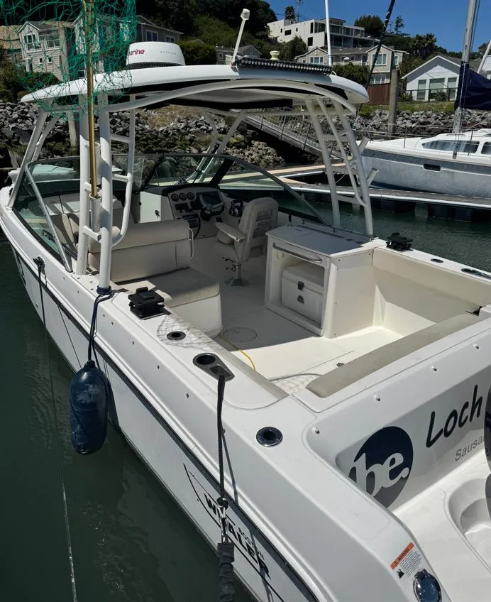 Slide: The Image of 2016 Boston Whaler 270 Dauntless boat docked in marina, featuring spacious seating and fishing equipment. - 2