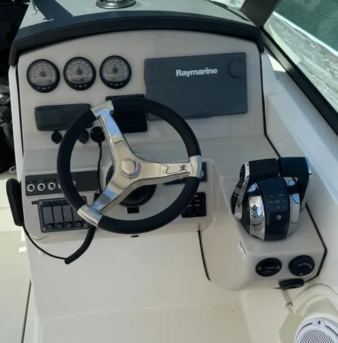 Slide: The Image of 2016 Boston Whaler 270 Dauntless helm with steering wheel and Raymarine electronics. - 4