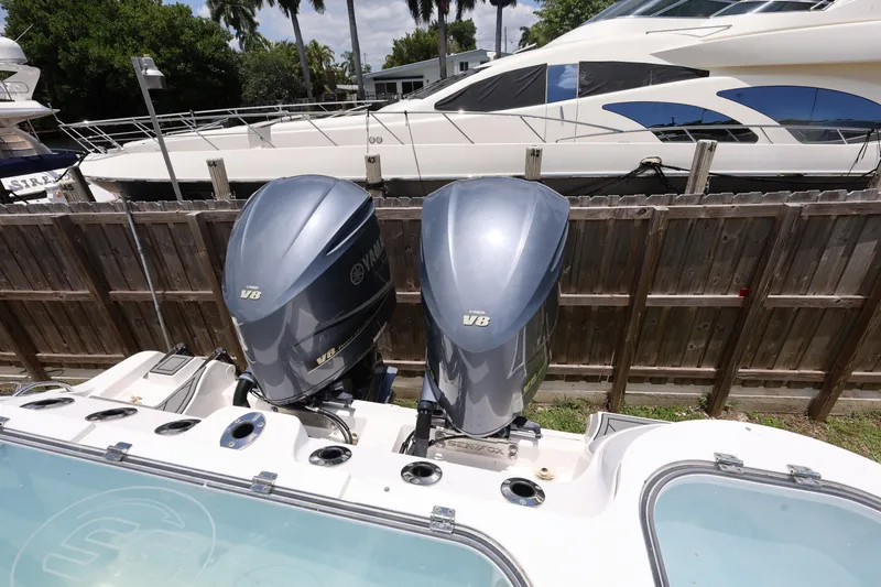 Slide: The Image of Twin Yamaha V8 engines on a 2020 Sea Fox 328 Commander boat, docked near a yacht. - 30