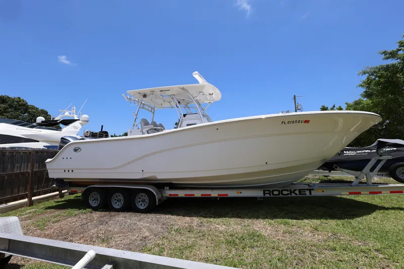 Slide: The Image of 2020 Sea Fox 328 Commander boat on trailer under clear blue sky. - 34