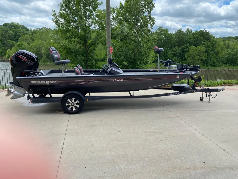 Slide: The Image of 2019 Ranger RT188 boat on trailer, parked outdoors with lush greenery in the background. - 7