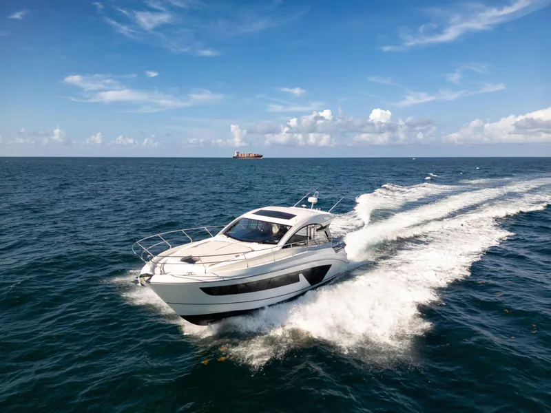 Slide: The Image of 2023 Beneteau Gran Turismo 45 yacht cruising on open sea under clear skies. - 1