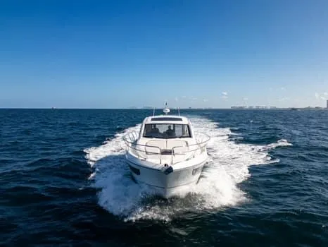 Slide: The Image of 2023 Beneteau Gran Turismo 45 yacht cruising on open sea under clear blue sky. - 2
