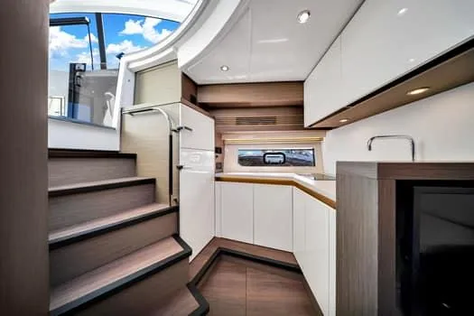 Slide: The Image of Interior of 2023 Beneteau Gran Turismo 45 yacht, featuring modern kitchen and staircase. - 26