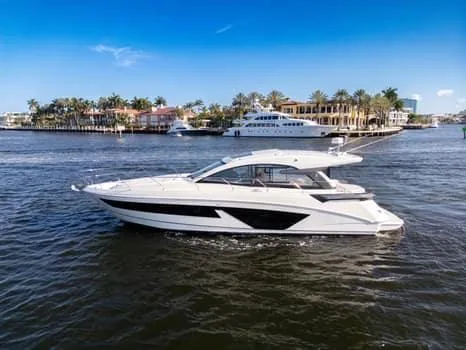 Slide: The Image of 2023 Beneteau Gran Turismo 45 yacht cruising on a sunny day near waterfront homes. - 3