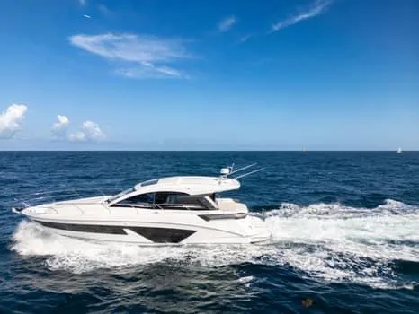 Slide: The Image of 2023 Beneteau Gran Turismo 45 yacht cruising on open sea under clear blue sky. - 47