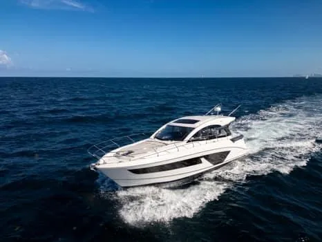 Slide: The Image of 2023 Beneteau Gran Turismo 45 yacht cruising on open sea under clear blue sky. - 7