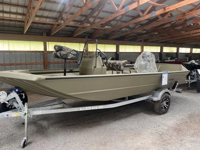 Slide: The Image of 2025 Lowe RX1760 Pathfinder boat on trailer in covered storage area. - 1