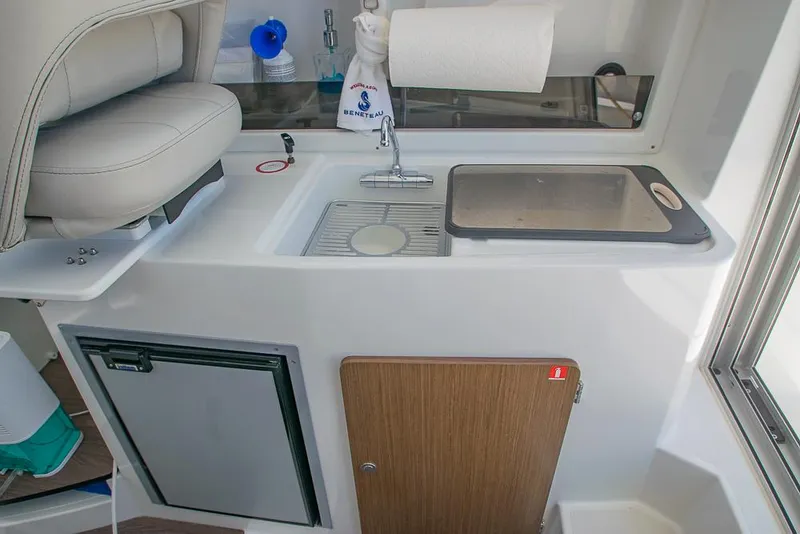 Slide: The Image of Compact kitchen area in 2021 Beneteau Antares 8 boat with sink and storage. - 11