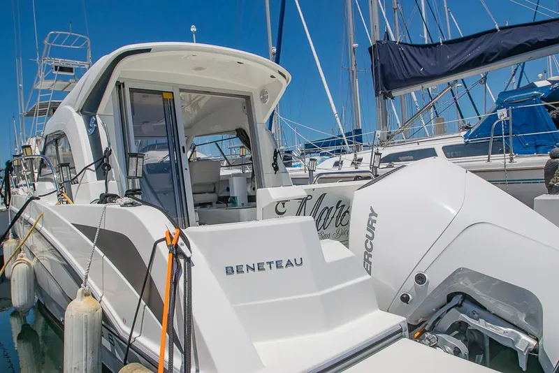 Slide: The Image of 2021 Beneteau Antares 8 boat docked, featuring a Mercury outboard engine. - 5