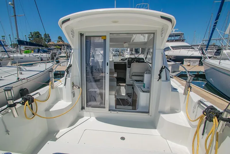 Slide: The Image of 2021 Beneteau Antares 8 boat interior, docked at marina, showcasing cockpit and seating area. - 6