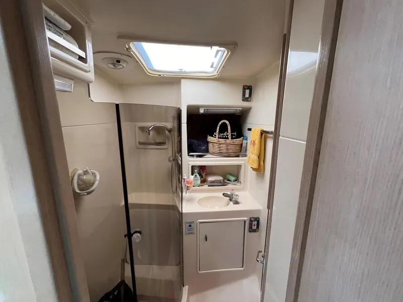 Slide: The Image of 1994 Tiara Yachts 3600 Convertible Sportfish bathroom with shower, sink, and storage shelves. - 11