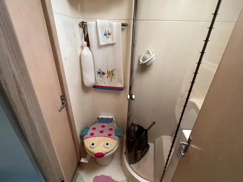 Slide: The Image of Bathroom in 1994 Tiara Yachts 3600 Convertible Sportfish, featuring playful decor and compact shower. - 13