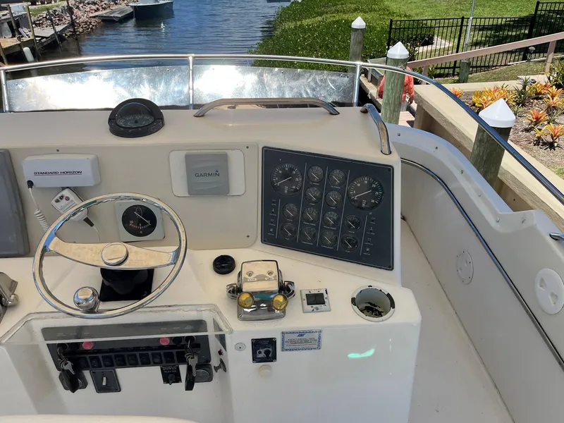Slide: The Image of 1994 Tiara Yachts 3600 Convertible Sportfish helm with steering wheel and control panel. - 19