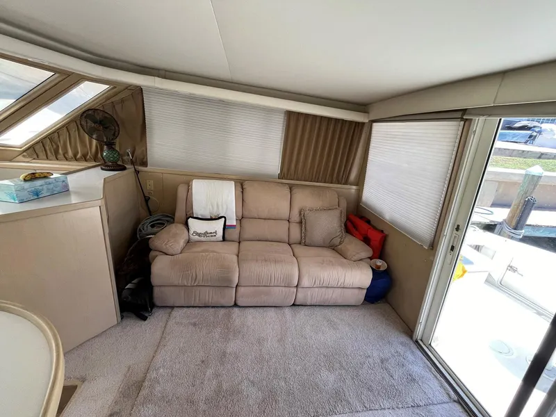 Slide: The Image of Interior of 1994 Tiara Yachts 3600 Convertible Sportfish with beige sofa and sliding glass door. - 3