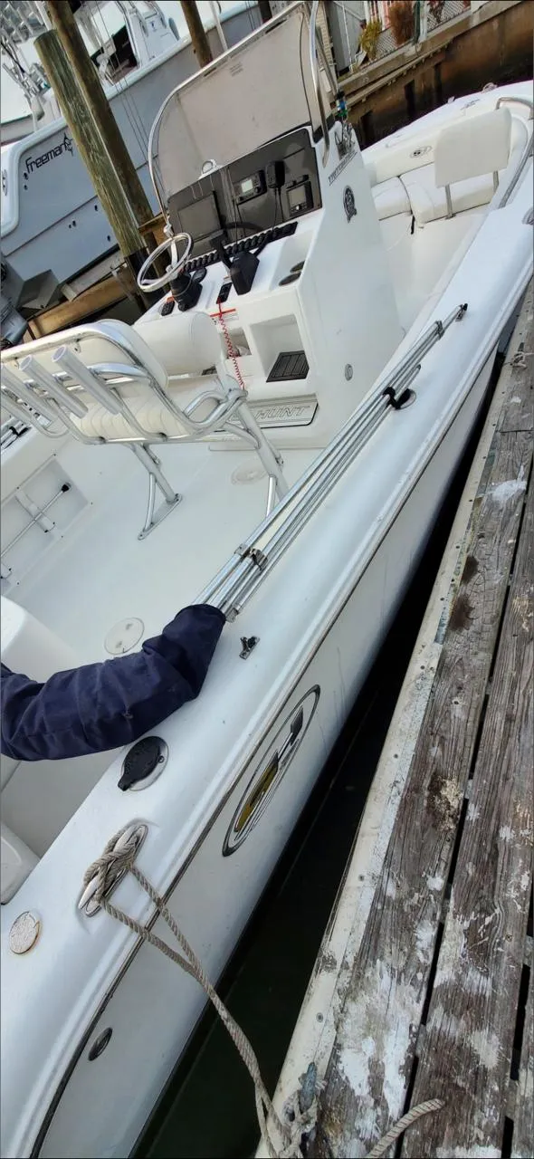 Slide: The Image of 2021 Sea Hunt Triton 225 boat docked, featuring a sleek white design and modern console. - 3