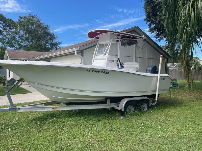 Slide: The Image of 2012 Tidewater 220 CC Adventure boat on trailer, parked beside a house. - 2