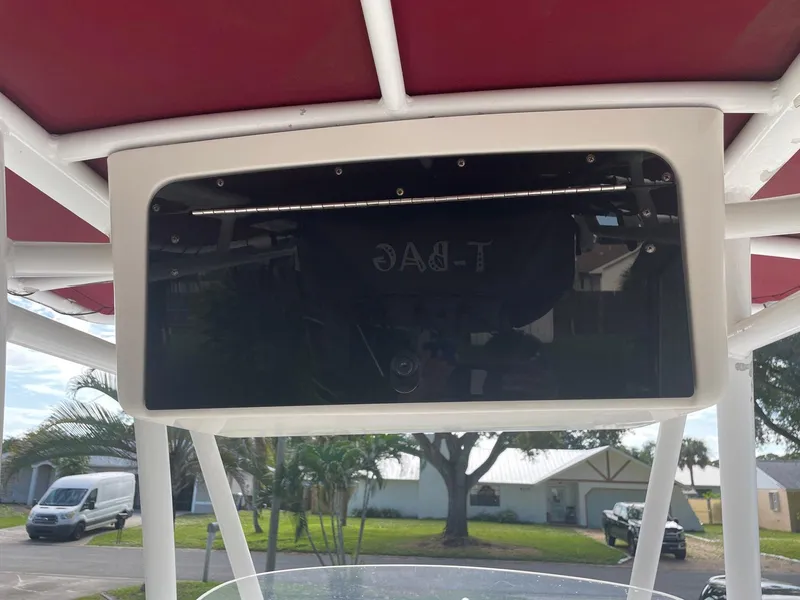 Slide: The Image of Tidewater 220 CC Adventure boat console, 2012 model, with red canopy and outdoor background. - 6