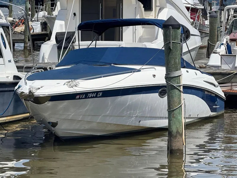 The Image of 2005 Chaparral 280 SSi boat docked in marina, featuring blue canopy and sleek design. - 0
