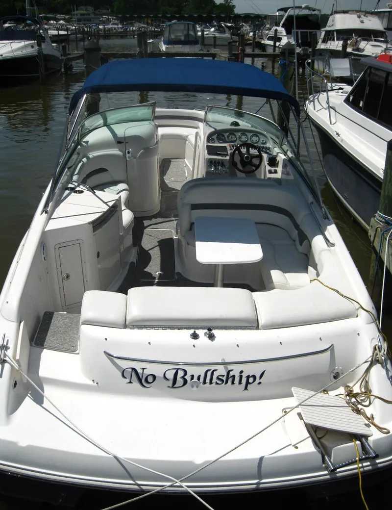 Slide: The Image of 2005 Chaparral 280 SSi boat docked, featuring spacious seating and a blue canopy. - 4