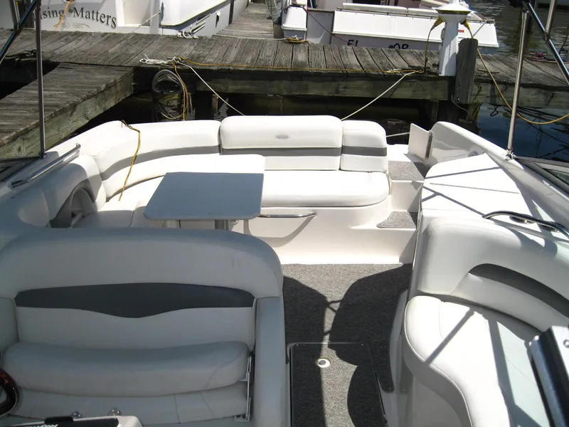 Slide: The Image of 2005 Chaparral 280 SSi boat interior with white seating and table at dock. - 5