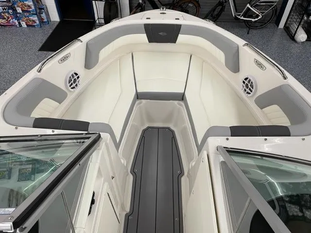 Slide: The Image of 2025 Chaparral 21 SSi OB boat interior with white and gray seating, modern design. - 2