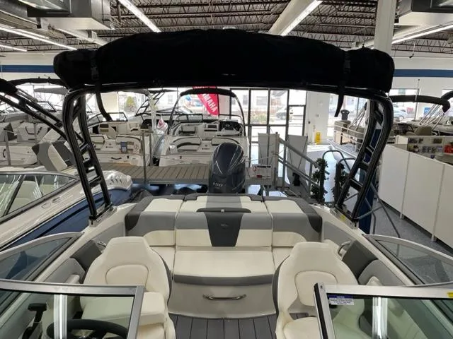 Slide: The Image of 2025 Chaparral 21 SSi OB boat interior with seating and outboard motor in showroom. - 4