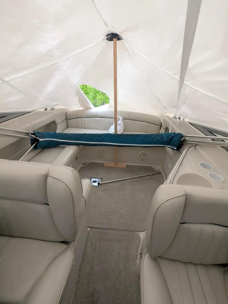 Slide: The Image of 1999 Crownline 266 CCR boat interior with beige seating and canopy cover. - 11