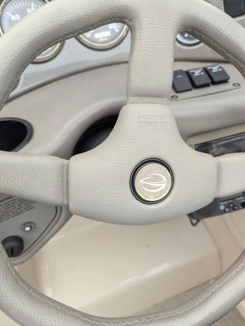 Slide: The Image of Steering wheel of a 1999 Crownline 266 CCR boat, featuring control panel and gauges. - 15