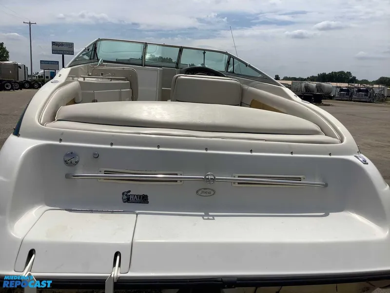 Slide: The Image of 1999 Crownline 266 CCR boat, rear view, white seating, parked outdoors. - 4