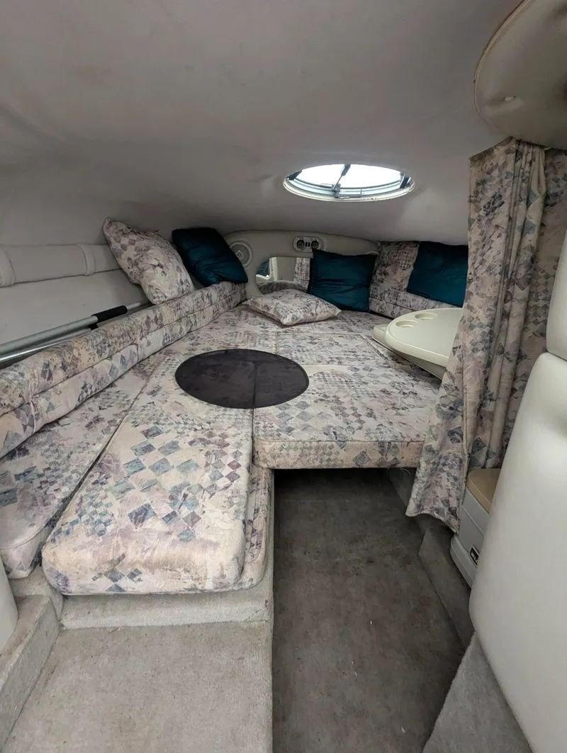 Slide: The Image of 1999 Crownline 266 CCR cabin interior with floral upholstery and round window. - 6