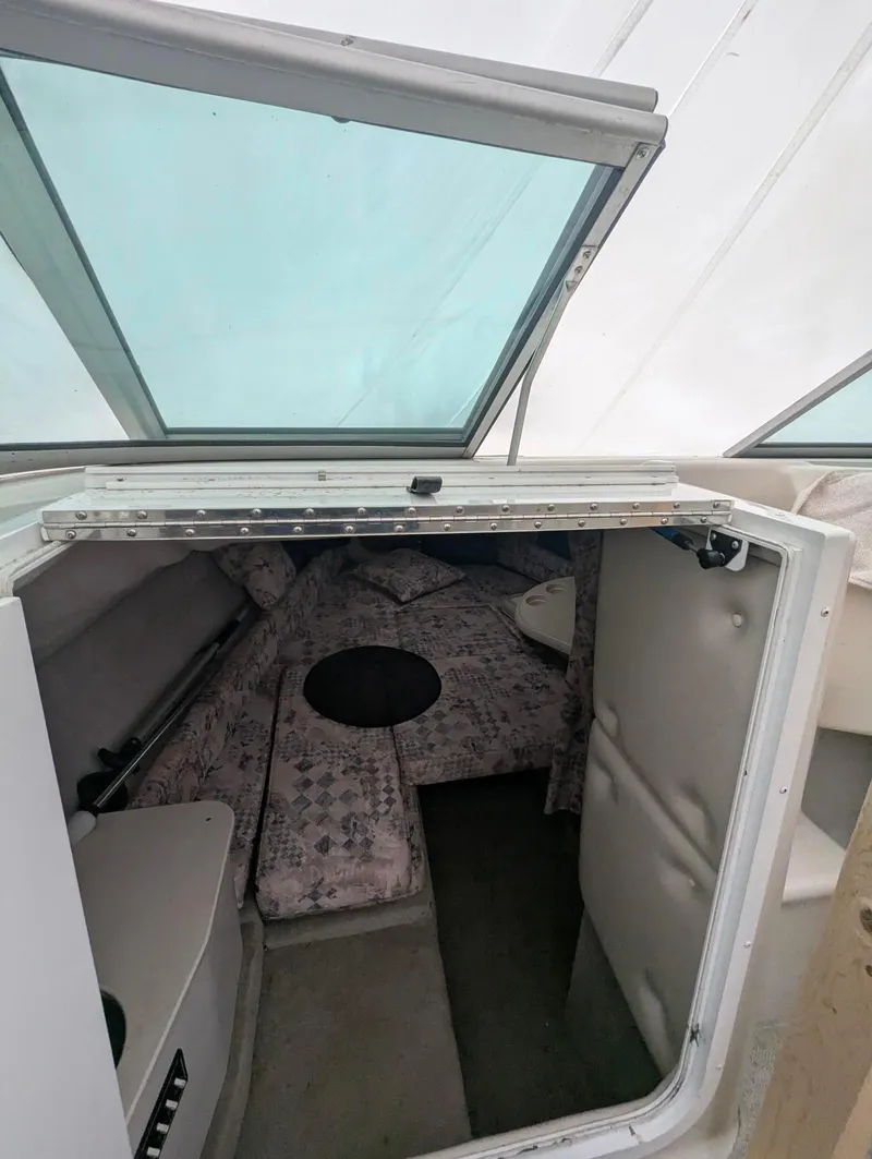 Slide: The Image of 1999 Crownline 266 CCR cabin interior with seating and windows. - 9