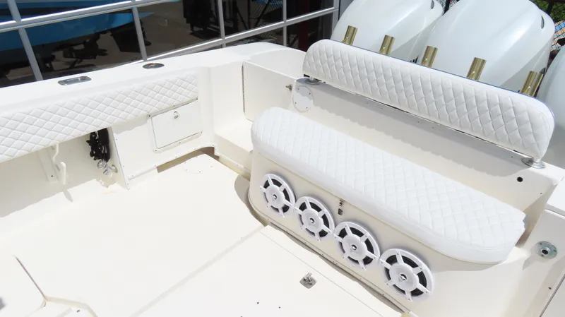 Slide: The Image of 2002 Fountain 38 TE boat interior with white quilted seating and speakers. - 11