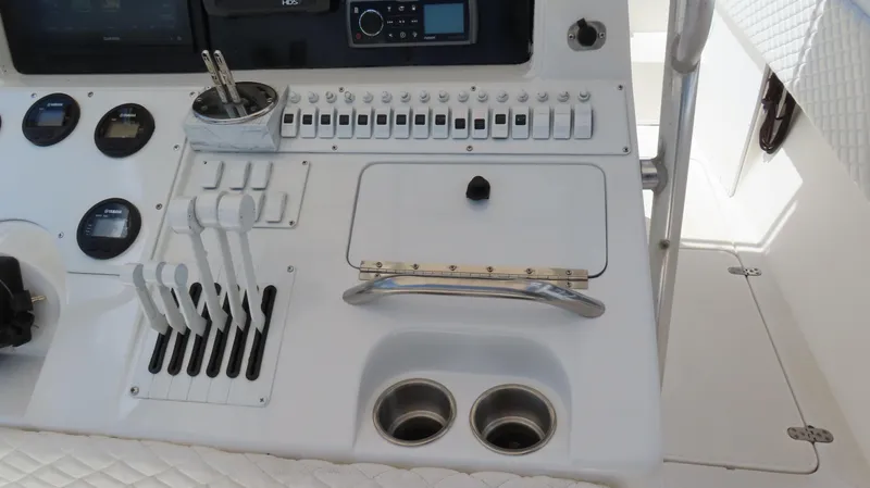 Slide: The Image of Control panel of a 2002 Fountain 38 TE boat with switches and cup holders. - 16