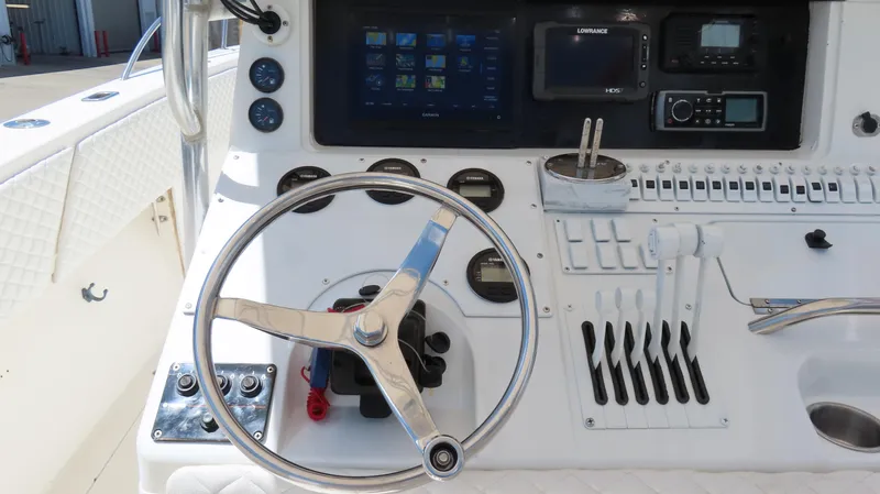 Slide: The Image of Control panel of a 2002 Fountain 38 TE boat with steering wheel and navigation instruments. - 17