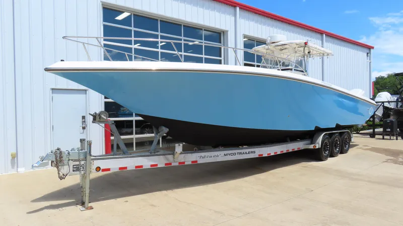 Slide: The Image of 2002 Fountain 38 TE boat on trailer, parked outside a building. - 2