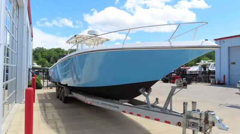 Slide: The Image of 2002 Fountain 38 TE boat on trailer, blue hull, parked outdoors near buildings. - 3