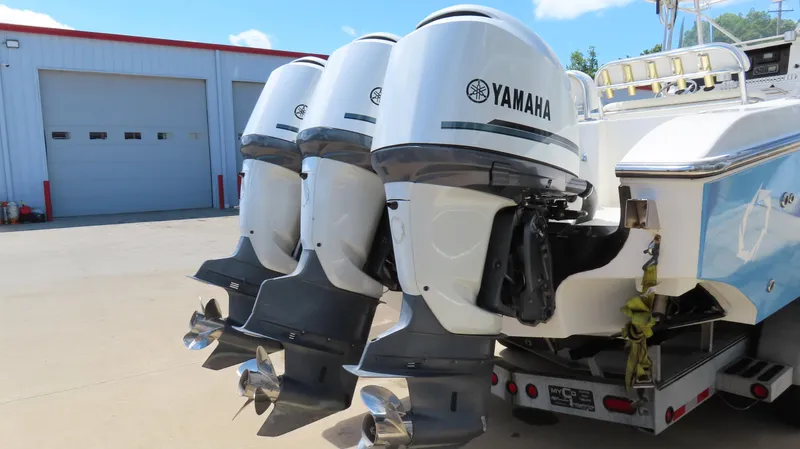Slide: The Image of Four Yamaha outboard motors on a 2002 Fountain 38 TE boat, parked near a garage. - 5