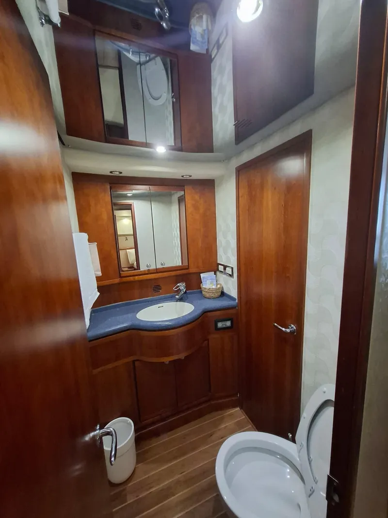 Slide: The Image of 2007 Bertram 630E yacht bathroom with wooden cabinetry and modern fixtures. - 12
