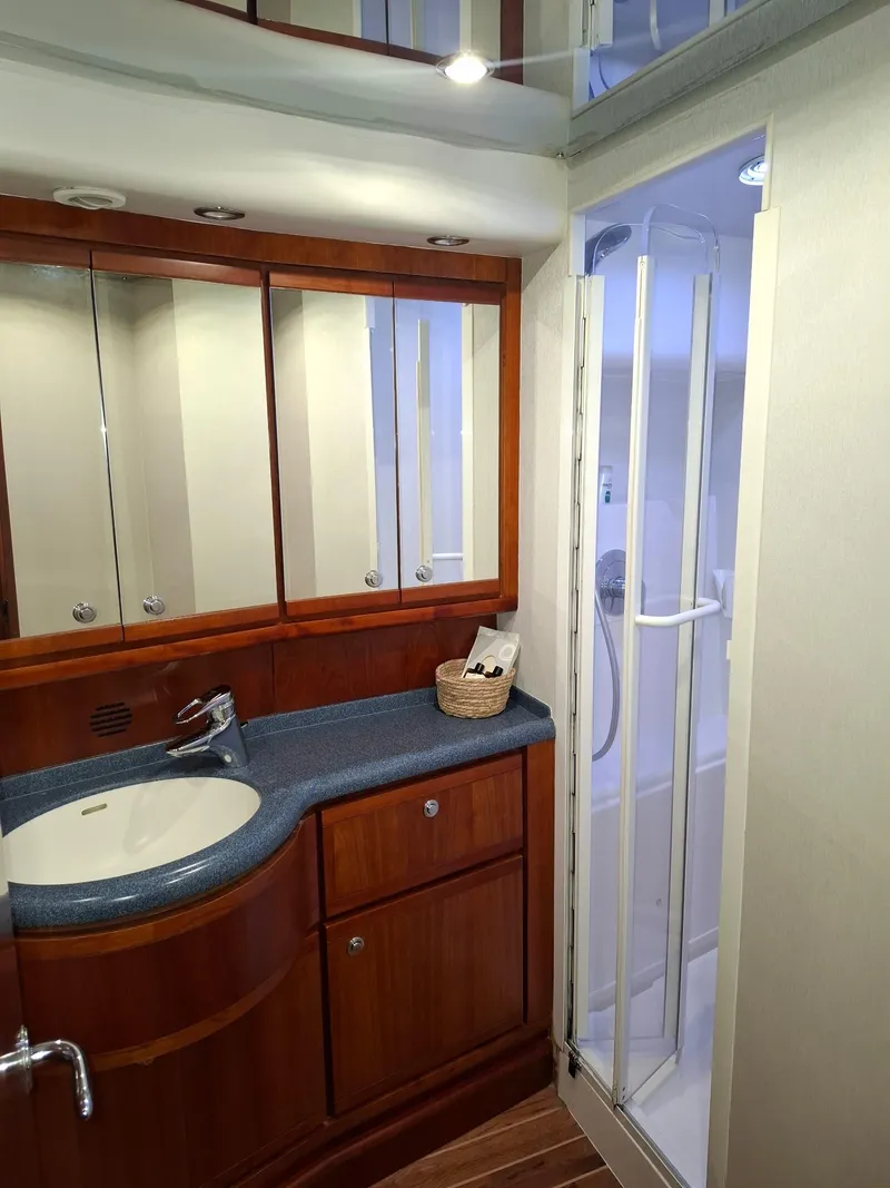 Slide: The Image of 2007 Bertram 630E yacht bathroom with wooden cabinetry and modern shower. - 14