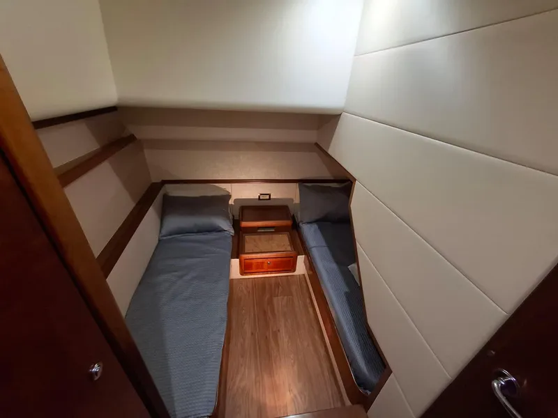 Slide: The Image of 2007 Bertram 630E cabin with twin beds and wooden flooring. - 15