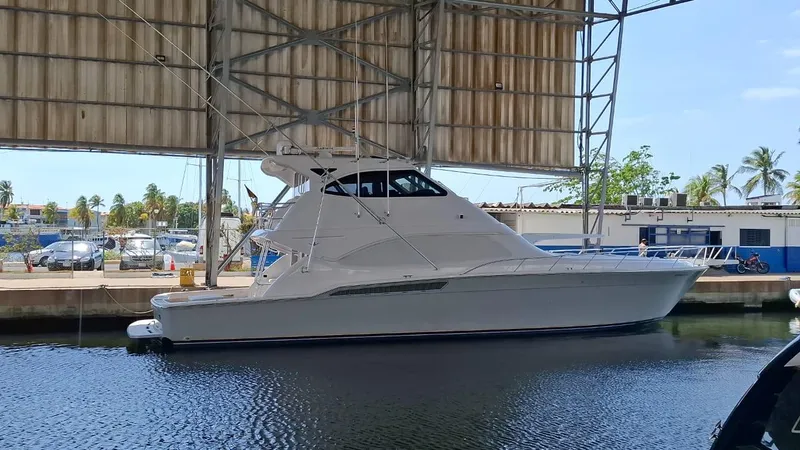 Slide: The Image of 2007 Bertram 630E yacht docked under a covered marina, side view. - 27