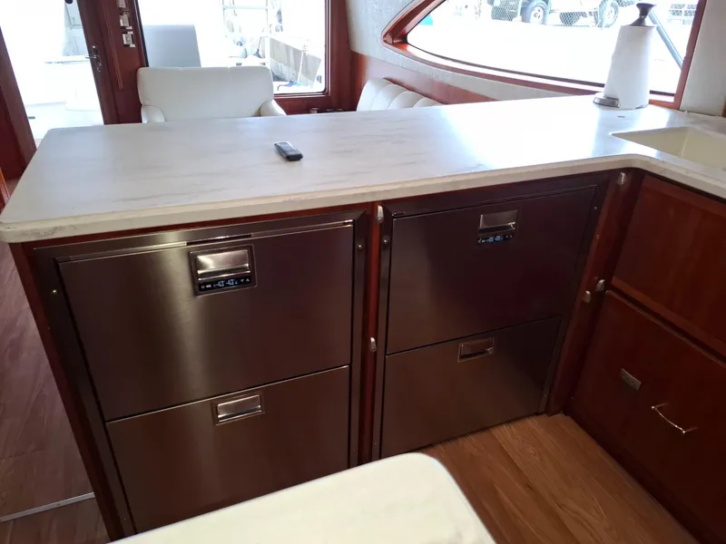 Slide: The Image of 2007 Bertram 630E yacht interior with modern kitchen appliances and sleek countertop design. - 4