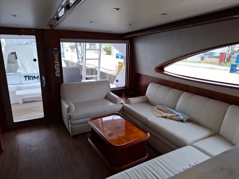 Slide: The Image of Luxurious interior of a 2007 Bertram 630E yacht with white leather seating and wooden table. - 6